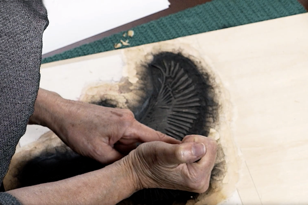 April Vollmer carves kingfisher woodblock prints.